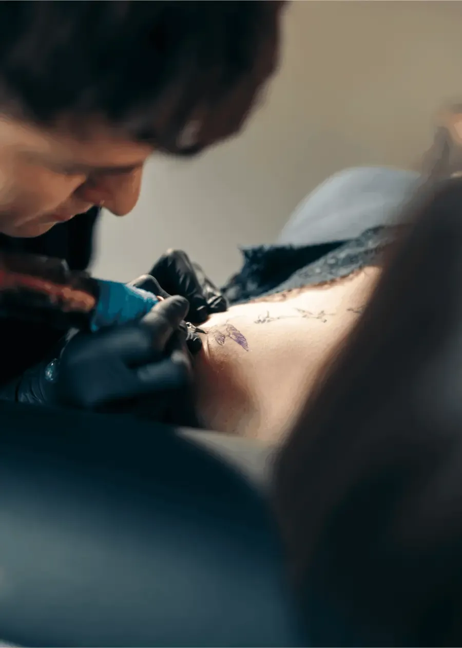 Tätowierer bei der Arbeit an einem Tattoo im Studio